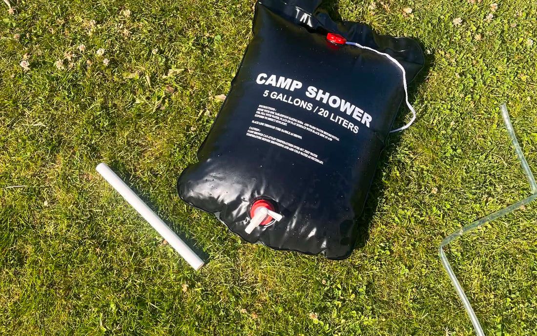 Camp Shower lagt ud på græsset i solen, så vandet kan varme op